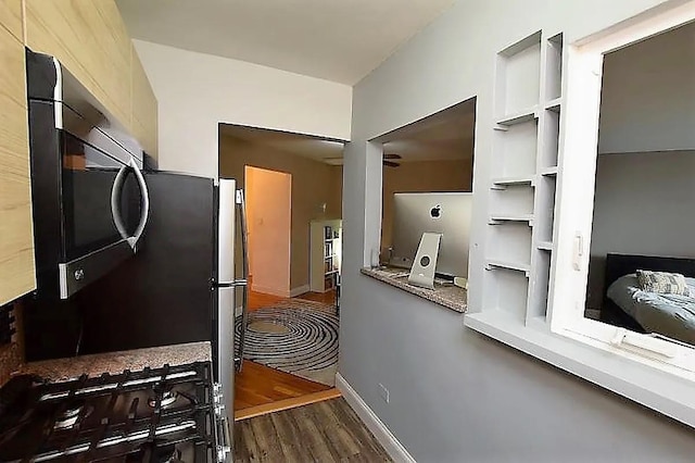 kitchen featuring built in features, wood finished floors, and baseboards