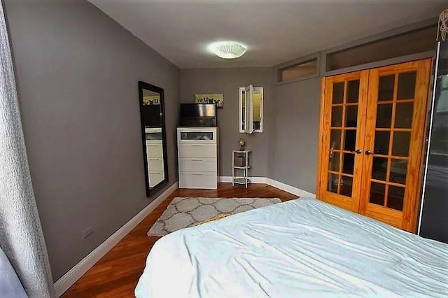 bedroom featuring french doors, baseboards, and dark wood finished floors