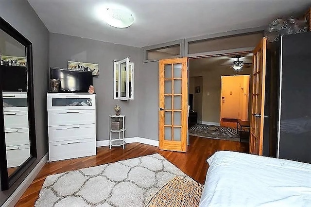 bedroom featuring french doors, baseboards, and wood finished floors