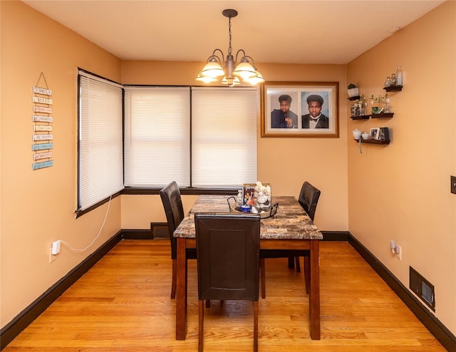 dining area featuring an inviting chandelier, visible vents, baseboards, and light wood finished floors