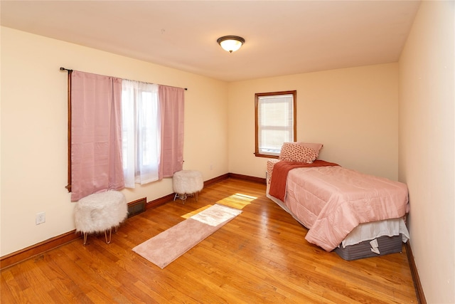 bedroom with light wood-style flooring and baseboards