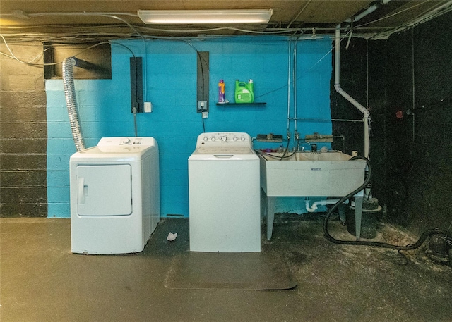 clothes washing area with a sink, laundry area, and washer and clothes dryer