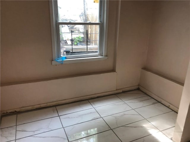 spare room with marble finish floor