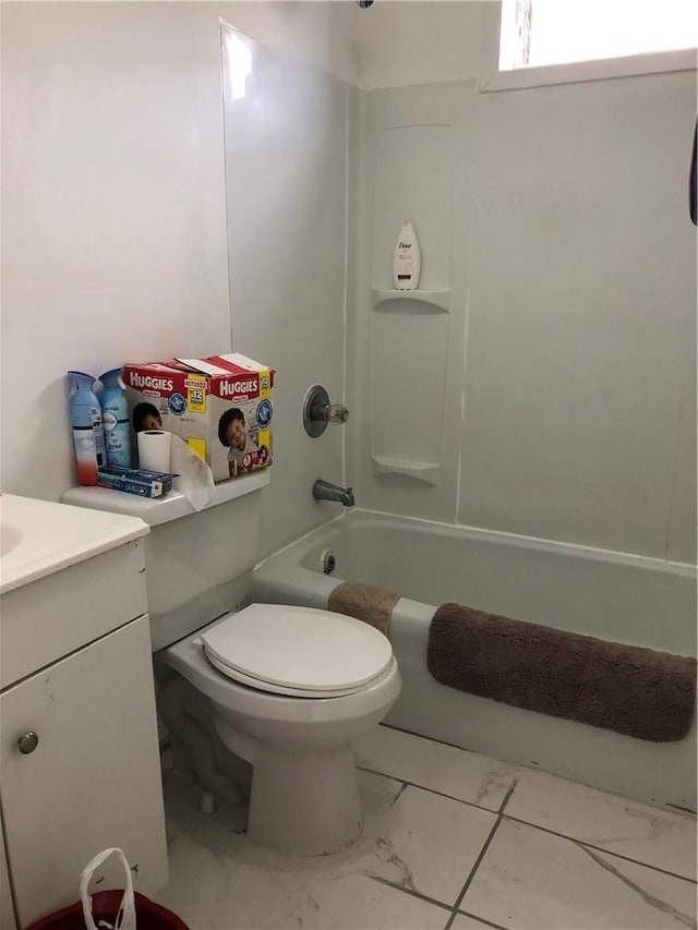 bathroom featuring vanity, toilet, marble finish floor, and shower / bath combination