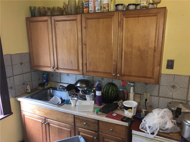 kitchen featuring brown cabinetry and a sink