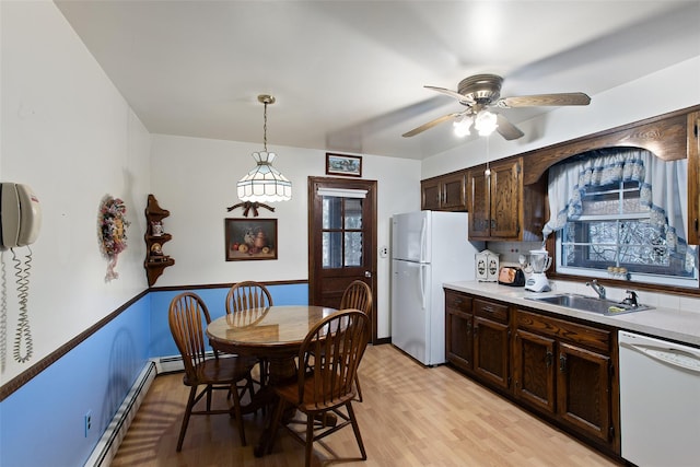 kitchen with dark brown cabinets, white appliances, a ceiling fan, and a sink