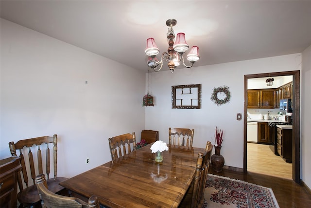 dining area with light wood-style flooring and a chandelier