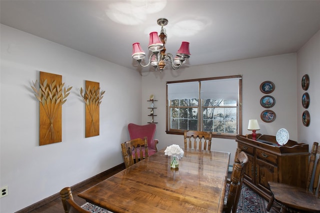 dining space featuring a notable chandelier and baseboards