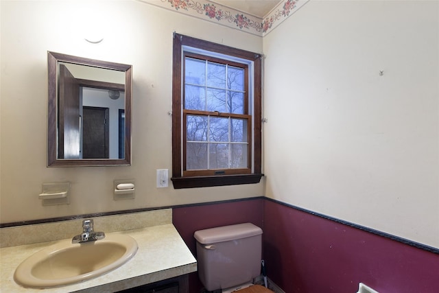 half bathroom with vanity and toilet