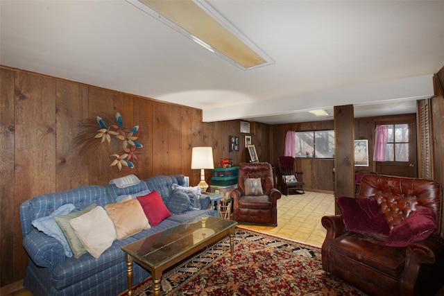 living room featuring tile patterned floors and wood walls