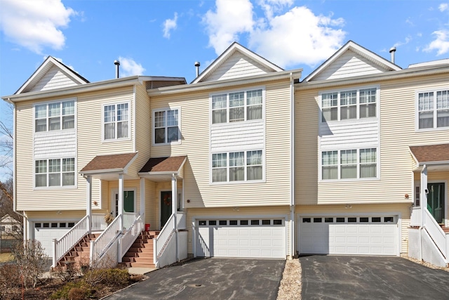 townhome / multi-family property with stairs, a garage, and driveway