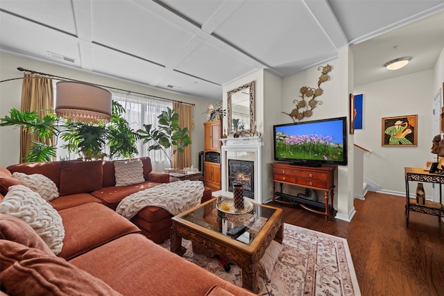 living area with baseboards, coffered ceiling, visible vents, dark wood-style flooring, and a lit fireplace