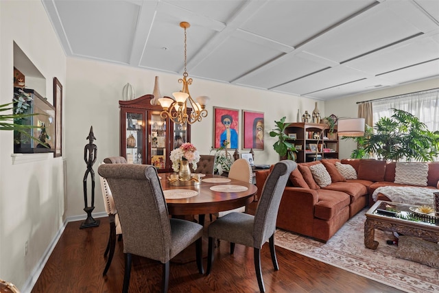 dining space with dark wood-style floors, a notable chandelier, and baseboards