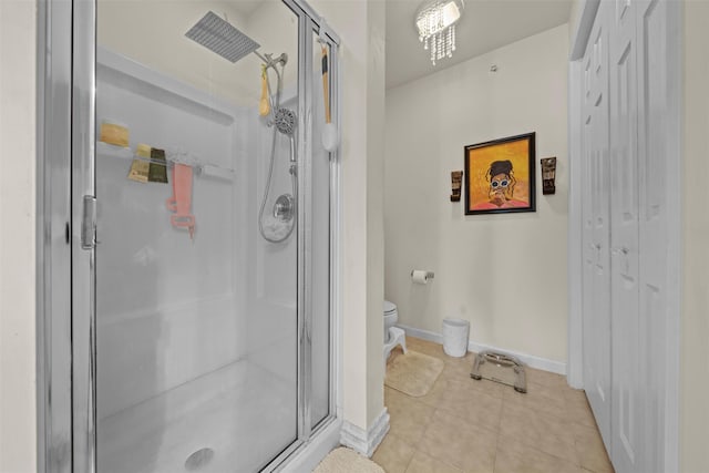 full bath featuring baseboards, toilet, a stall shower, and tile patterned flooring