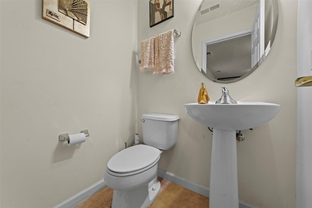 bathroom with tile patterned floors, visible vents, baseboards, and toilet