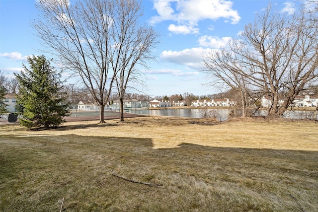 view of yard featuring a residential view and a water view