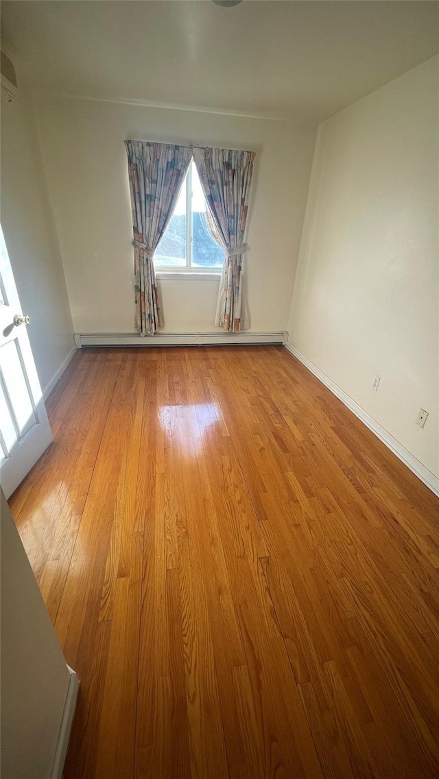 empty room with light wood finished floors and baseboards