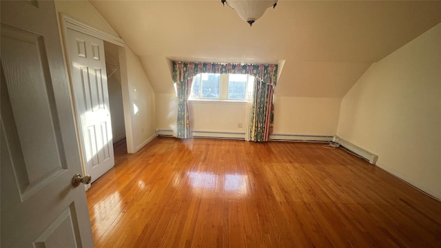 bonus room featuring light wood-type flooring, lofted ceiling, and a baseboard radiator