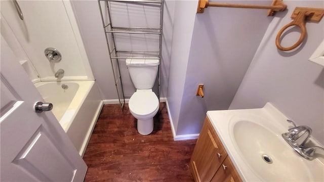 full bath with baseboards, toilet, shower / bath combination, wood finished floors, and vanity