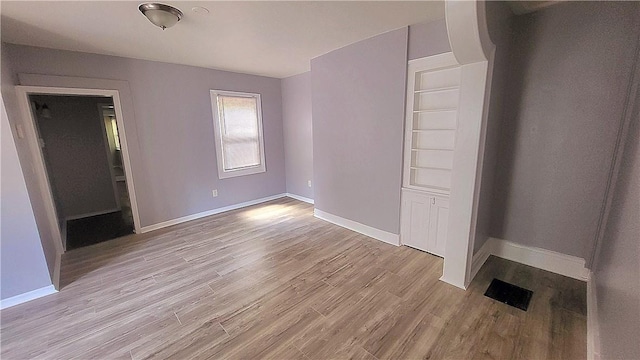 unfurnished bedroom featuring light wood-type flooring and baseboards