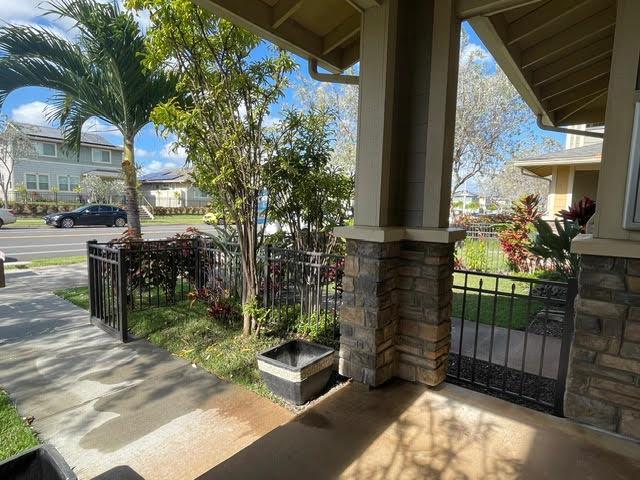 view of gate featuring covered porch and fence