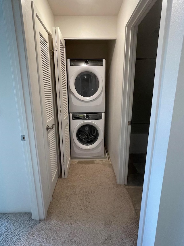 clothes washing area with laundry area, carpet flooring, and stacked washing maching and dryer