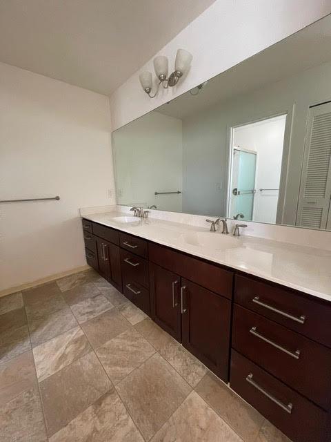 full bathroom featuring double vanity and a sink