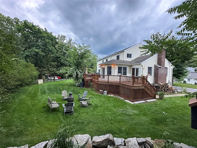 rear view of property with a yard and a wooden deck