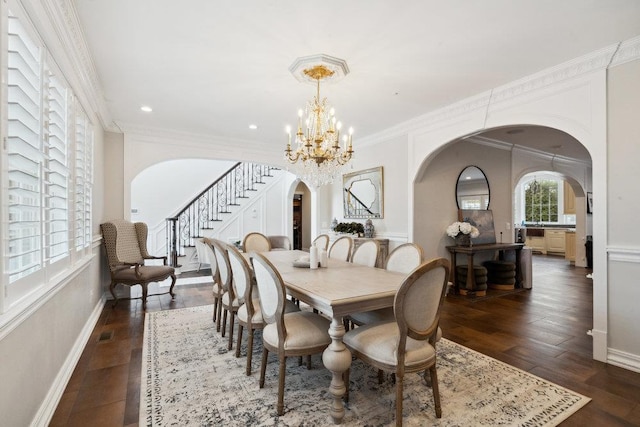 dining room with dark wood-style floors, stairway, arched walkways, crown molding, and a chandelier