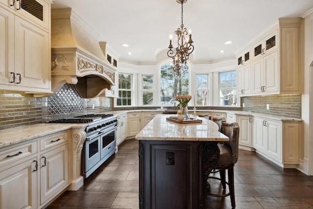 kitchen featuring double oven range, a kitchen breakfast bar, a center island, custom exhaust hood, and a chandelier