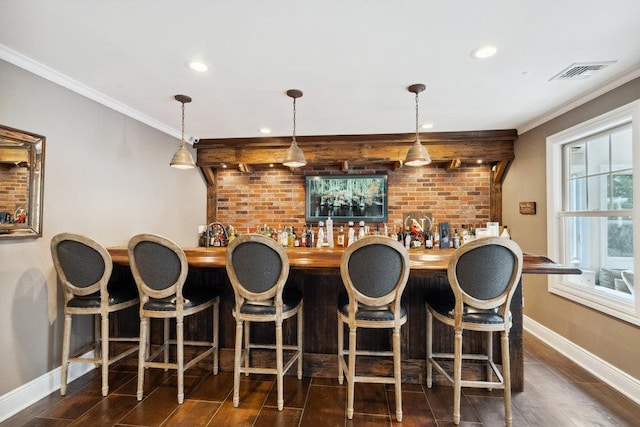 bar featuring visible vents, crown molding, baseboards, indoor wet bar, and wood finished floors