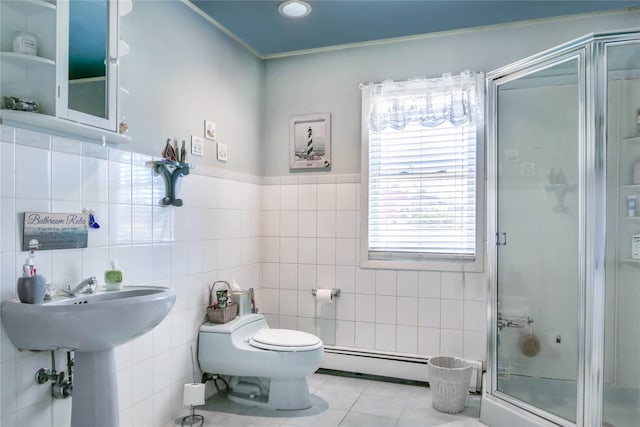 bathroom with tile patterned flooring, a shower stall, tile walls, toilet, and baseboard heating