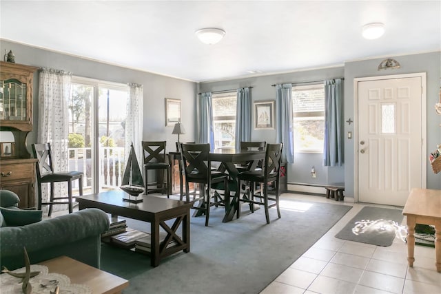 dining room featuring tile patterned floors, a baseboard heating unit, baseboards, and ornamental molding