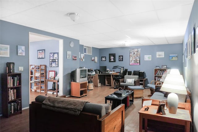 living area featuring wood finished floors and a paneled ceiling