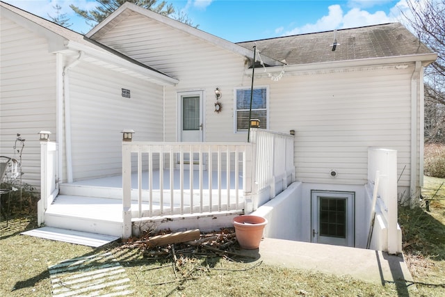 back of property featuring a shingled roof and a deck