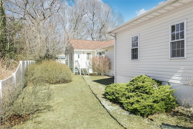 view of yard featuring entry steps and fence