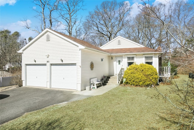 view of front of home with aphalt driveway, a front yard, and an attached garage