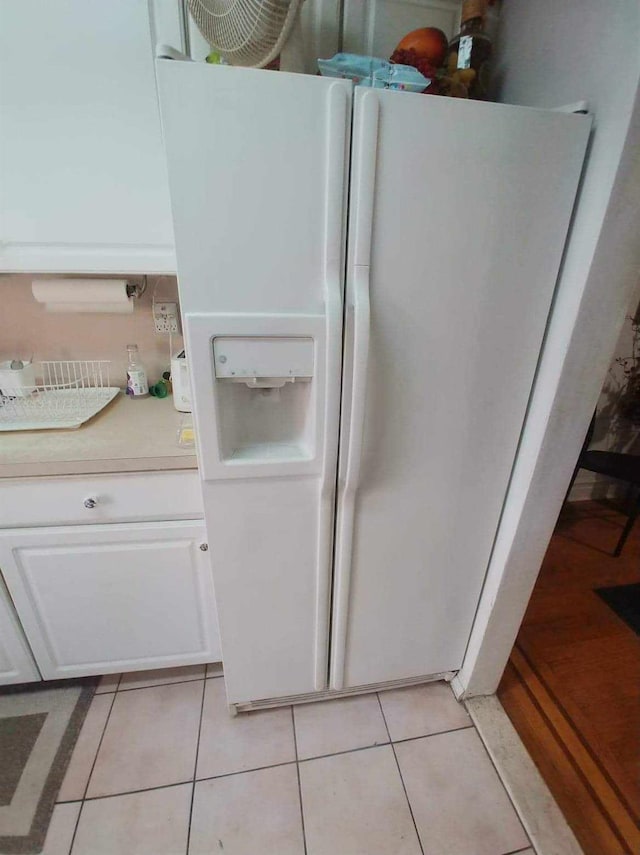 room details featuring light countertops, white cabinets, and white fridge with ice dispenser