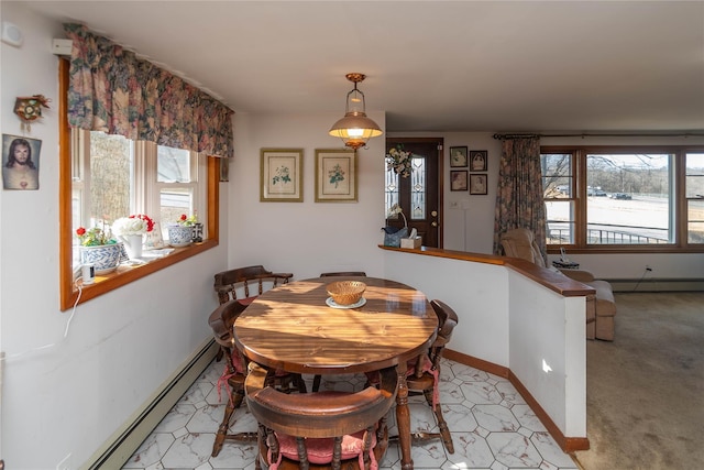 dining space with a baseboard heating unit and baseboards