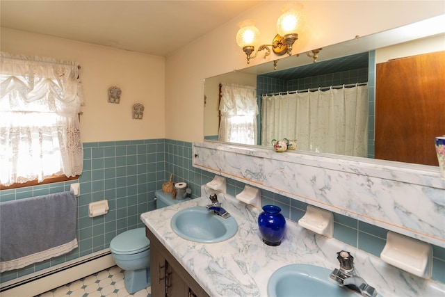 bathroom with a sink, baseboard heating, tile walls, and toilet