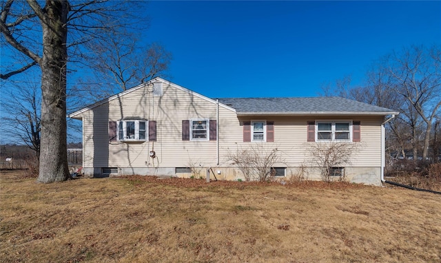 view of side of property with a yard and a shingled roof