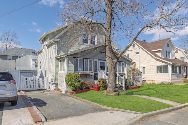 view of front facade with a front yard, a gate, fence, and a residential view