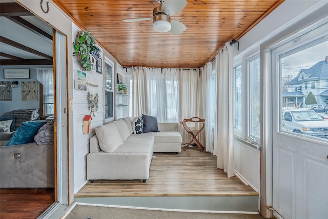 sunroom featuring wood ceiling and a ceiling fan