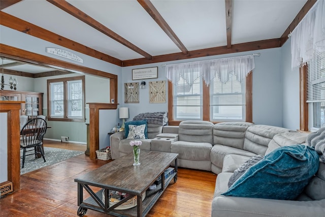 living room with beamed ceiling, visible vents, and wood-type flooring