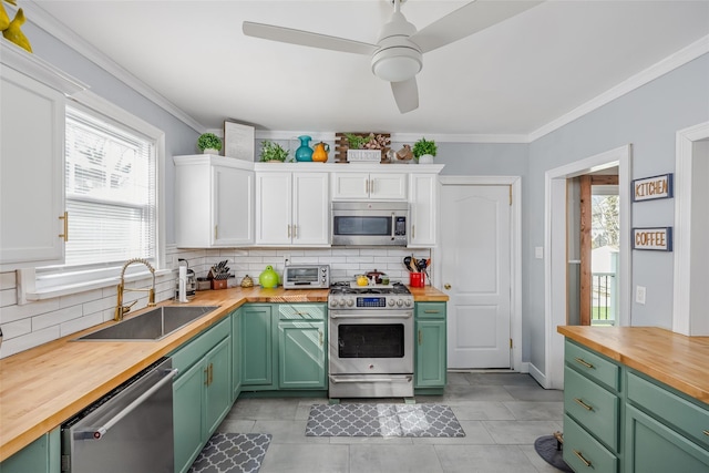 kitchen featuring a sink, stainless steel appliances, white cabinets, green cabinets, and butcher block counters