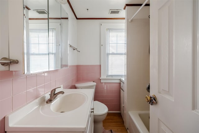 full bath with tile walls, visible vents, toilet, and vanity