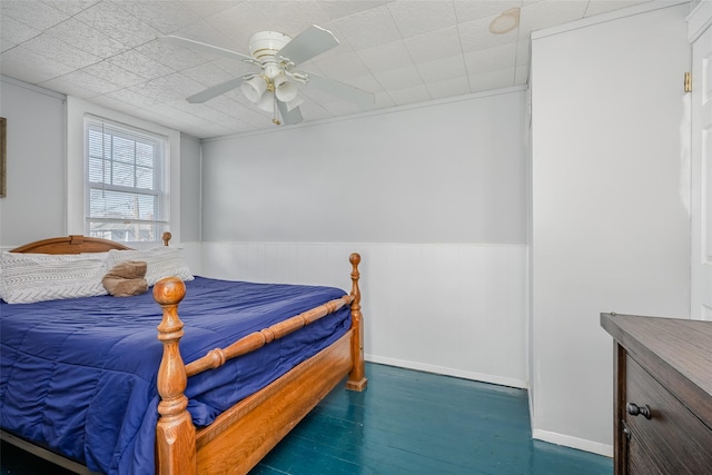 bedroom featuring a wainscoted wall and ceiling fan