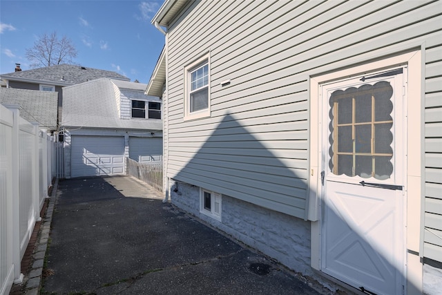 view of side of property with an outbuilding and fence