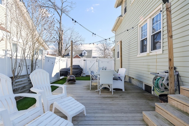 wooden deck featuring outdoor dining space, a fenced backyard, and grilling area