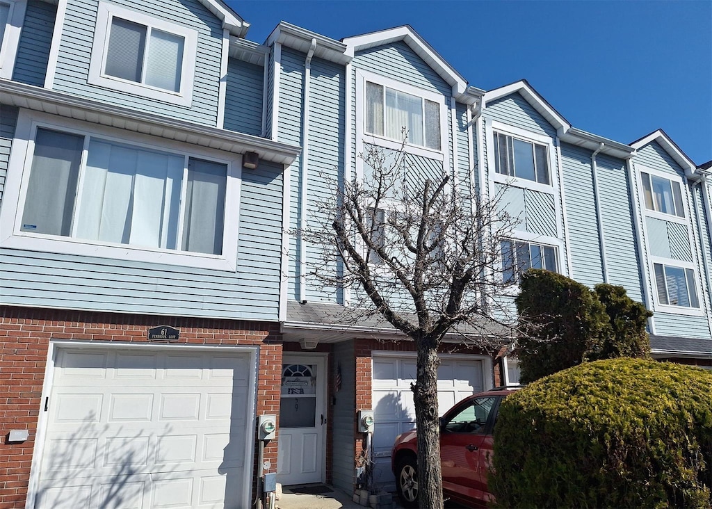 view of front of house featuring a garage and brick siding